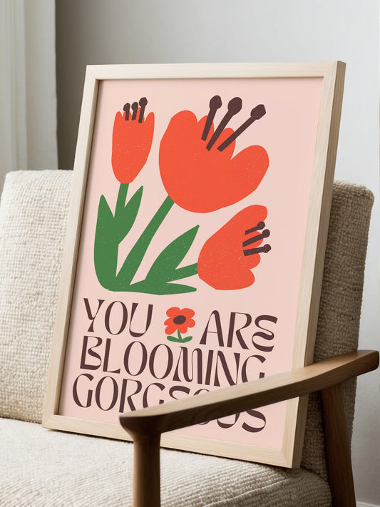 Motivational wall art print featuring red-orange flowers with hand motifs and, displayed in modern living room setting