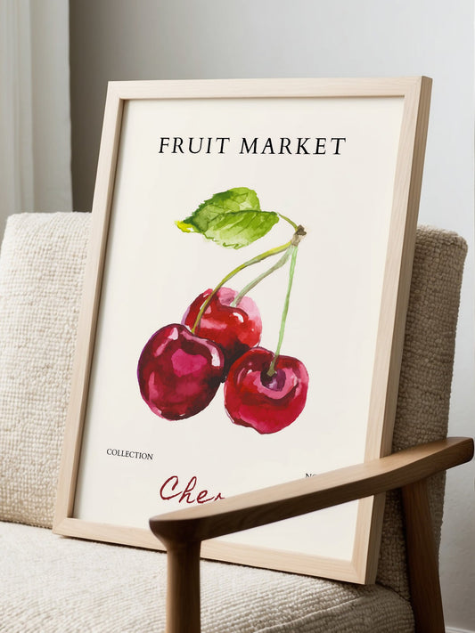 Botanical art print of three red cherries with green stems and leaves on cream, displayed in modern living room setting