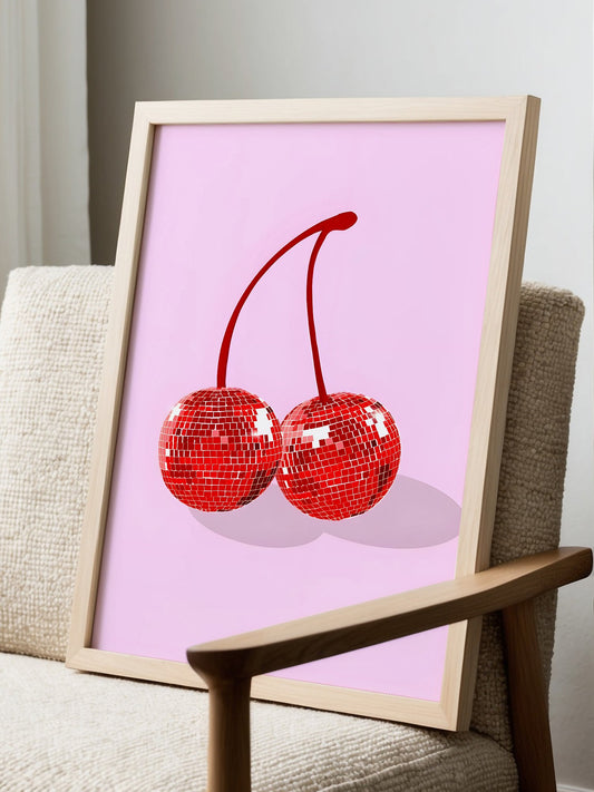 Pop art print of two disco ball cherries with geometric faceted surfaces in red, displayed in modern living room setting