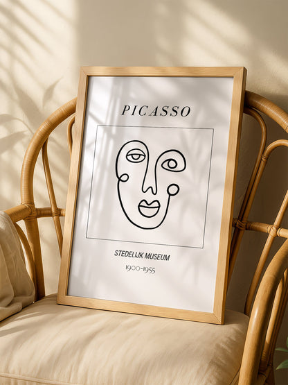 Abstract Picasso face art print featuring minimalist black line drawing on, shown in minimalist home office space