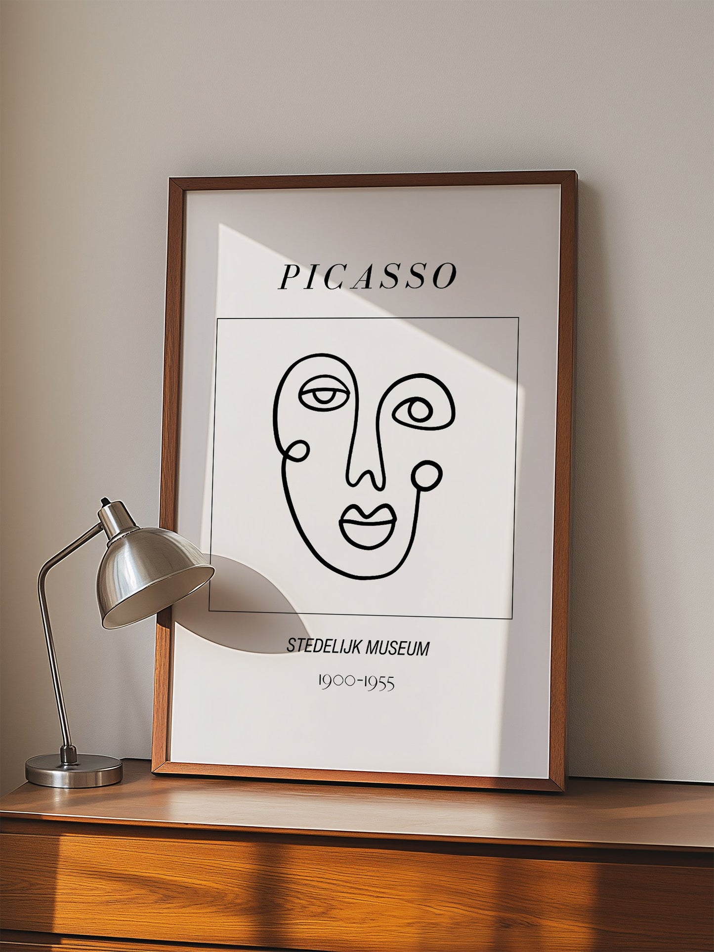 Abstract Picasso face art print featuring minimalist black line drawing on, displayed in modern living room setting