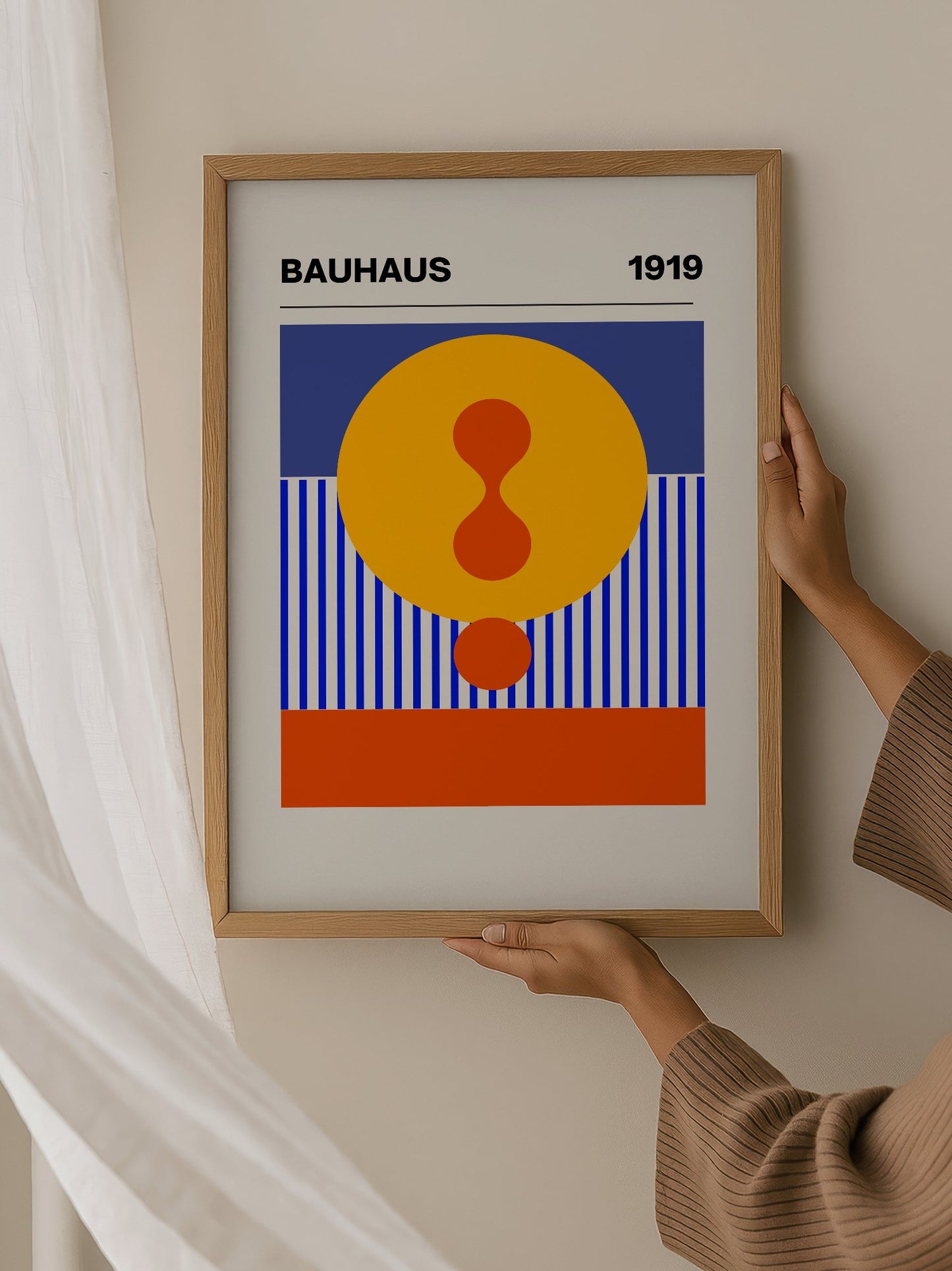 Bauhaus 1919 geometric poster featuring yellow circle with red hourglass shape, hanging in contemporary bedroom interior