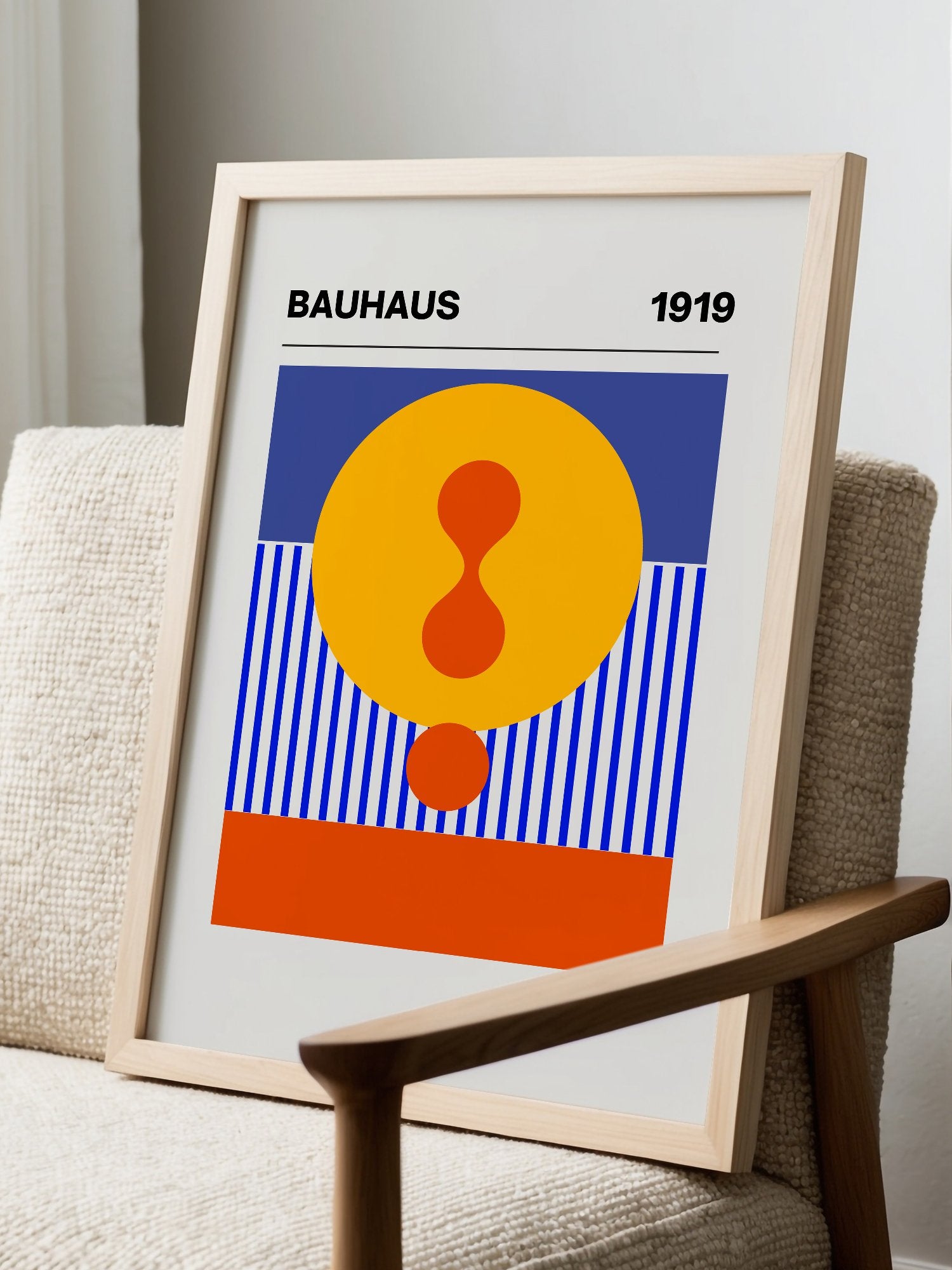 Bauhaus 1919 geometric poster featuring yellow circle with red hourglass shape, displayed in modern living room setting