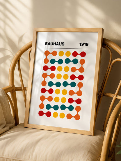 Bauhaus 1919 geometric wall art print featuring orange teal yellow and red, shown in minimalist home office space