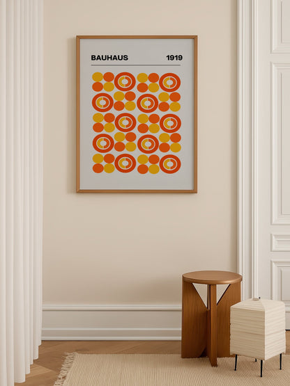 Bauhaus 1919 geometric poster featuring grid of orange and yellow concentric, shown in minimalist home office space