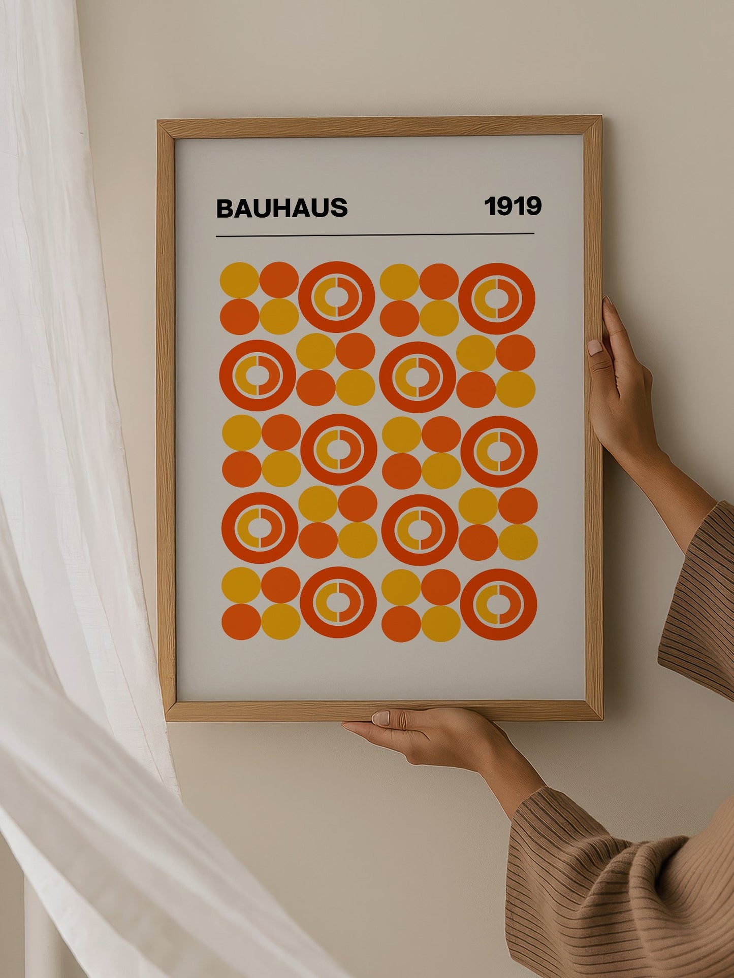 Bauhaus 1919 geometric poster featuring grid of orange and yellow concentric, hanging in contemporary bedroom interior