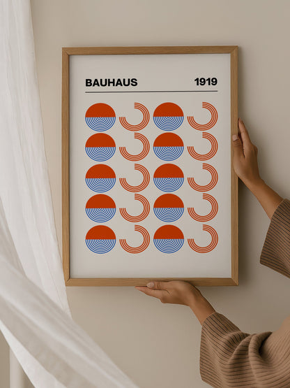 Bauhaus 1919 geometric poster featuring grid pattern of orange and blue, hanging in contemporary bedroom interior