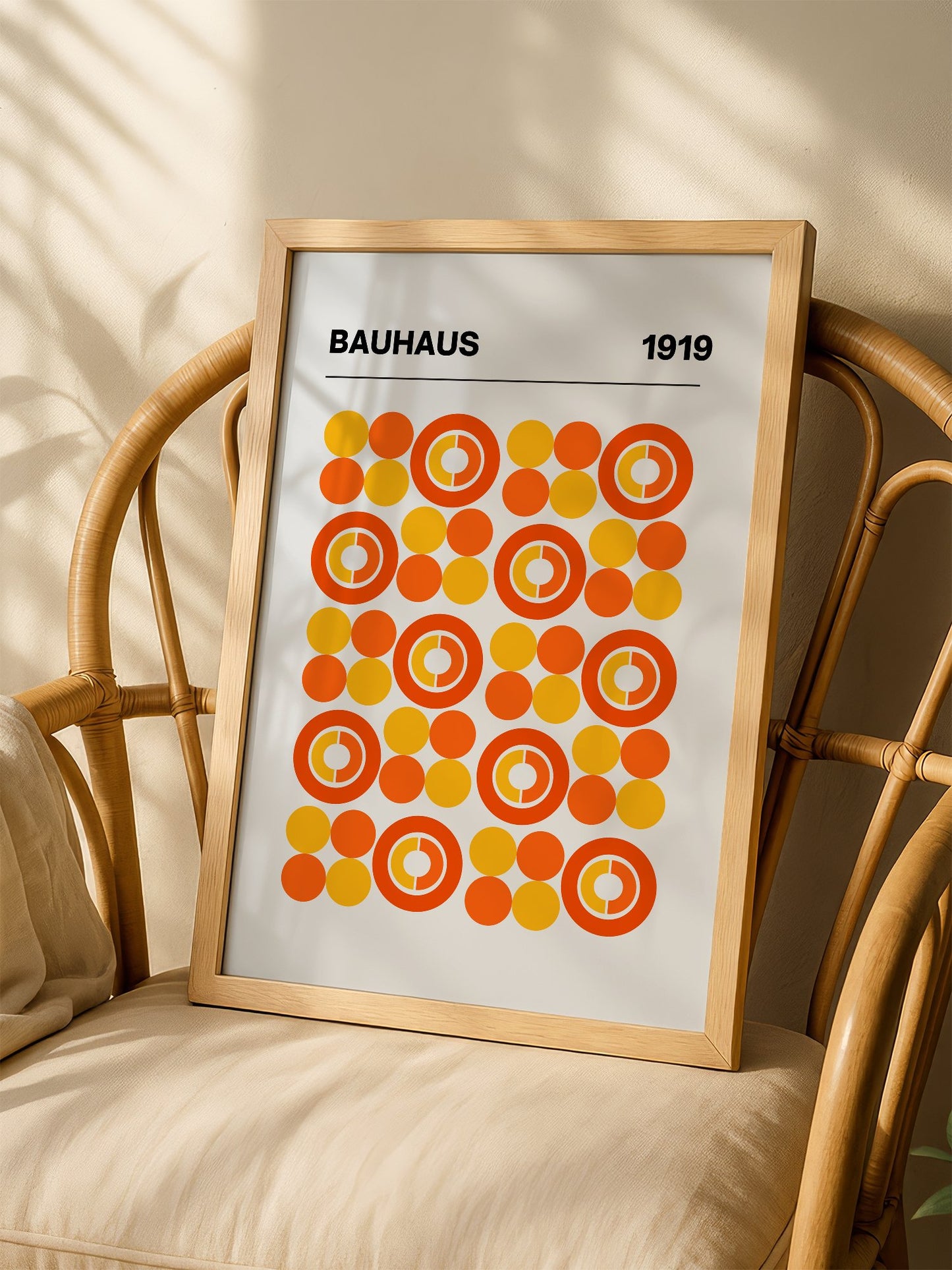 Bauhaus 1919 geometric poster featuring grid of orange and yellow concentric, shown in minimalist home office space