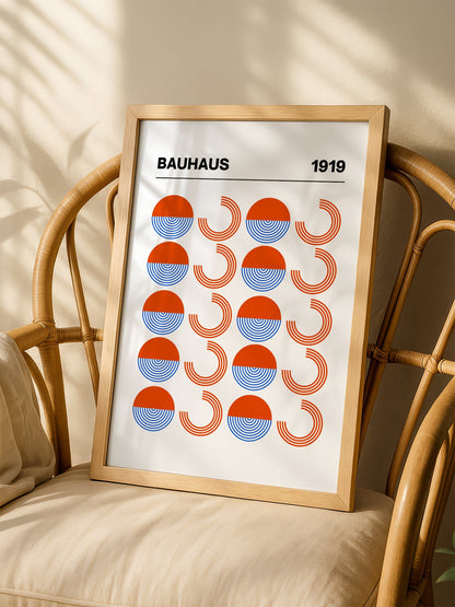 Bauhaus 1919 geometric poster featuring grid pattern of orange and blue, shown in minimalist home office space