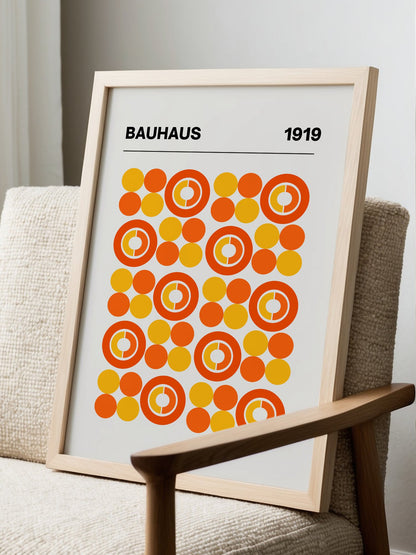 Bauhaus 1919 geometric poster featuring grid of orange and yellow concentric, displayed in modern living room setting