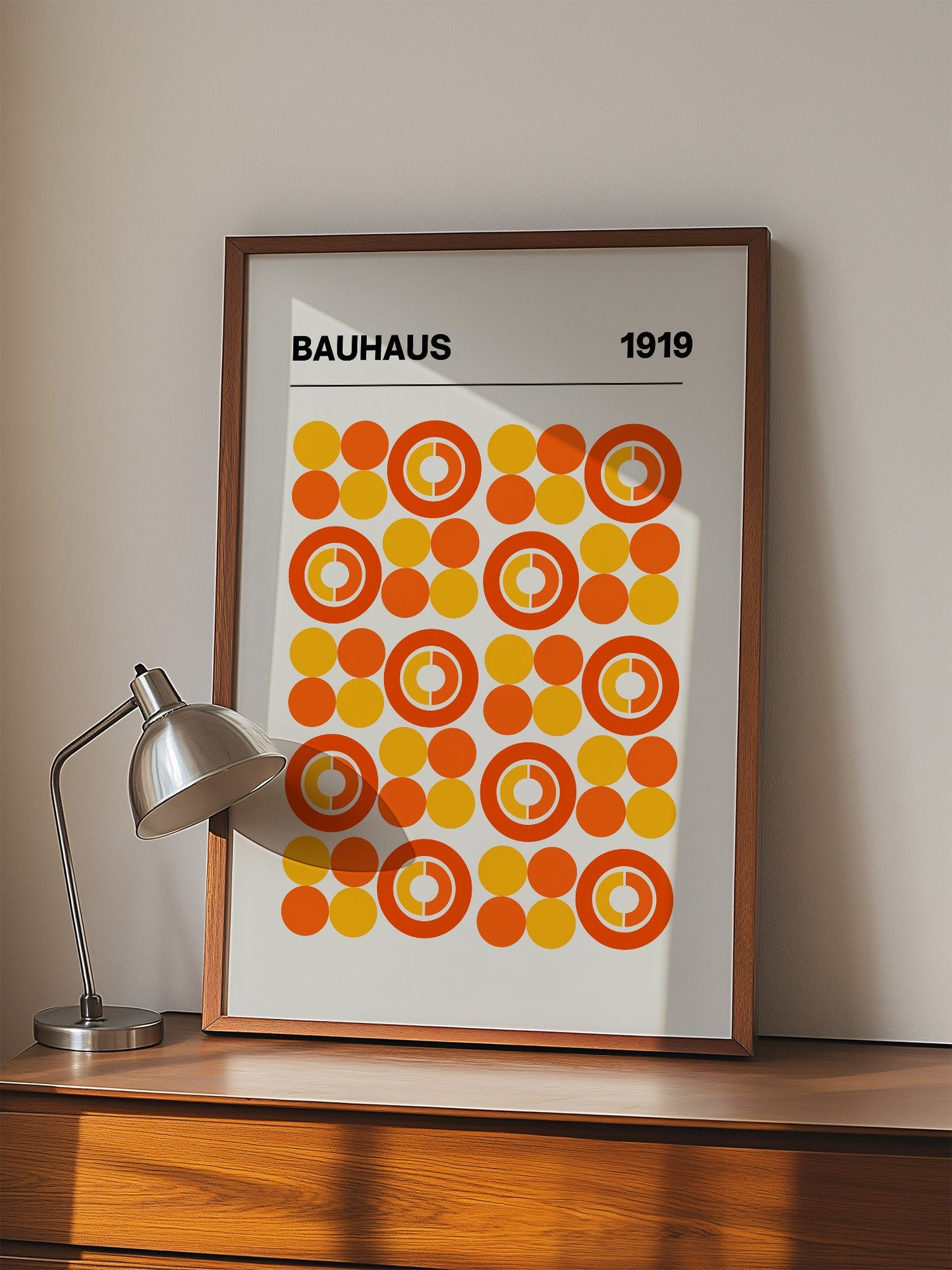 Bauhaus 1919 geometric poster featuring grid of orange and yellow concentric, displayed in modern living room setting