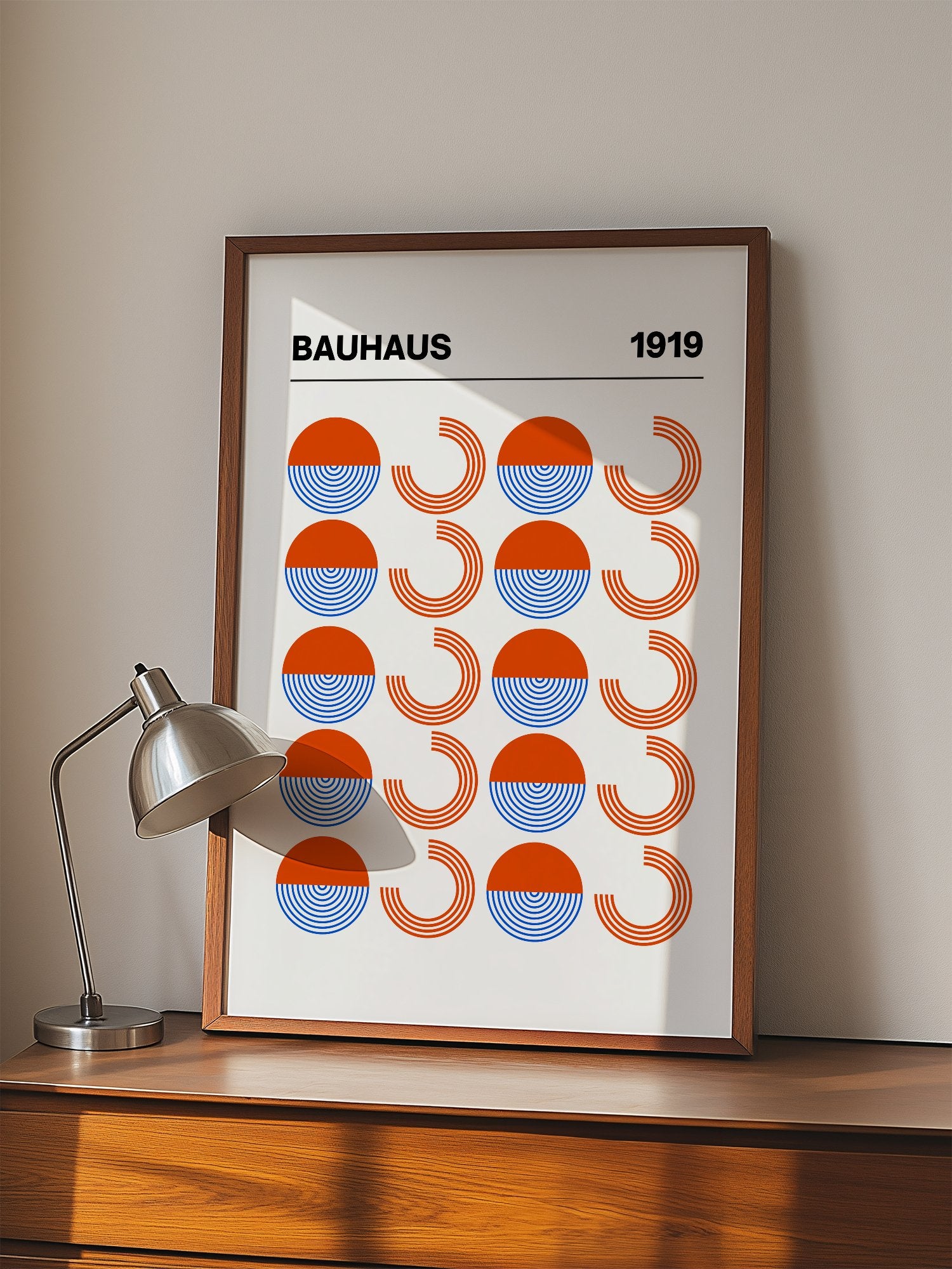 Bauhaus 1919 geometric poster featuring grid pattern of orange and blue, displayed in modern living room setting