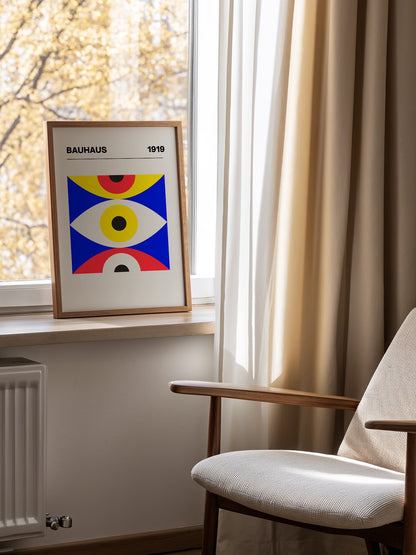 Bauhaus 1919 geometric poster with three stacked eye shapes in yellow red and, mounted in bright gallery wall arrangement