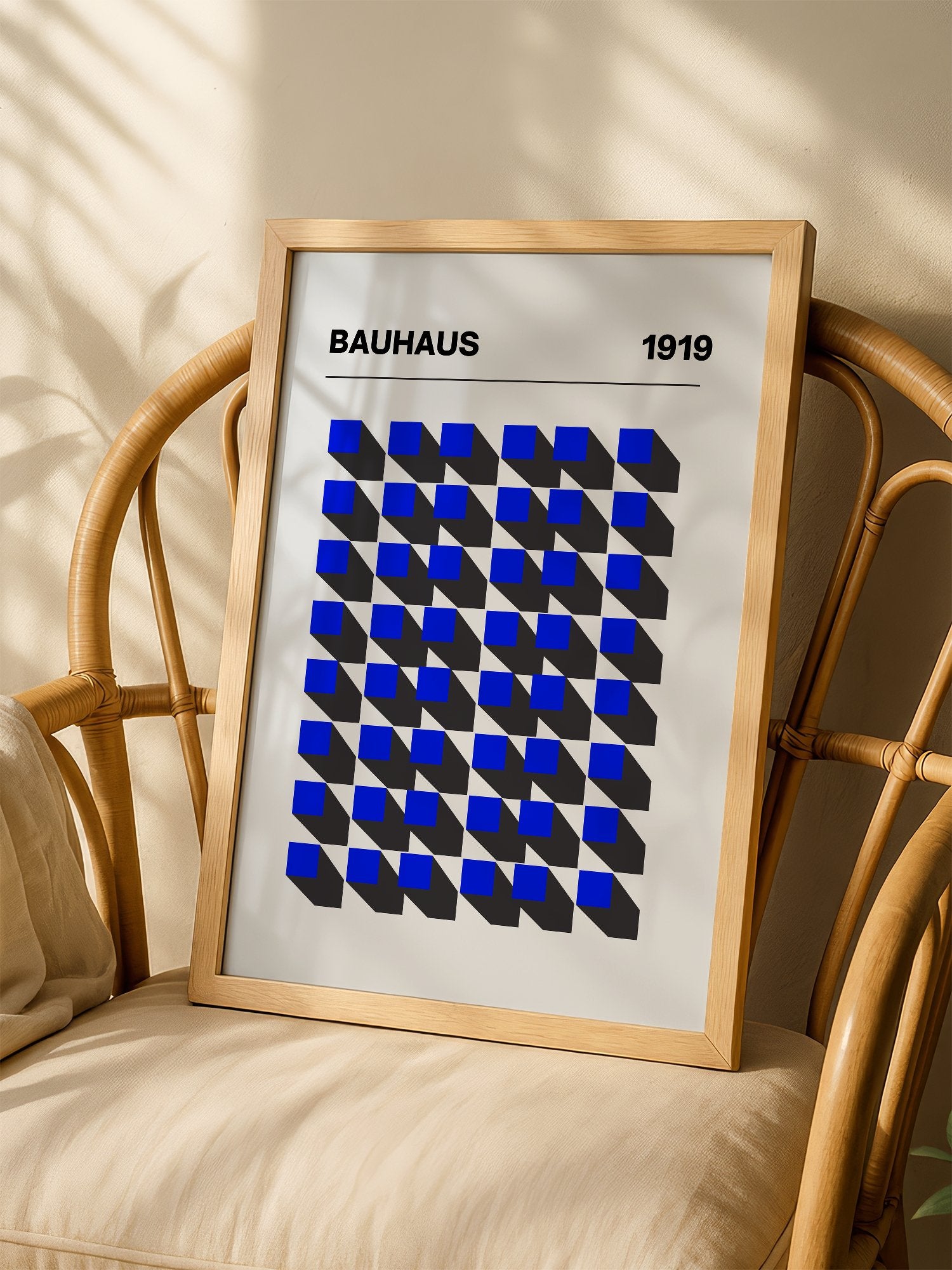 Bauhaus 1919 geometric poster featuring blue isometric cubes arranged in grid, shown in minimalist home office space