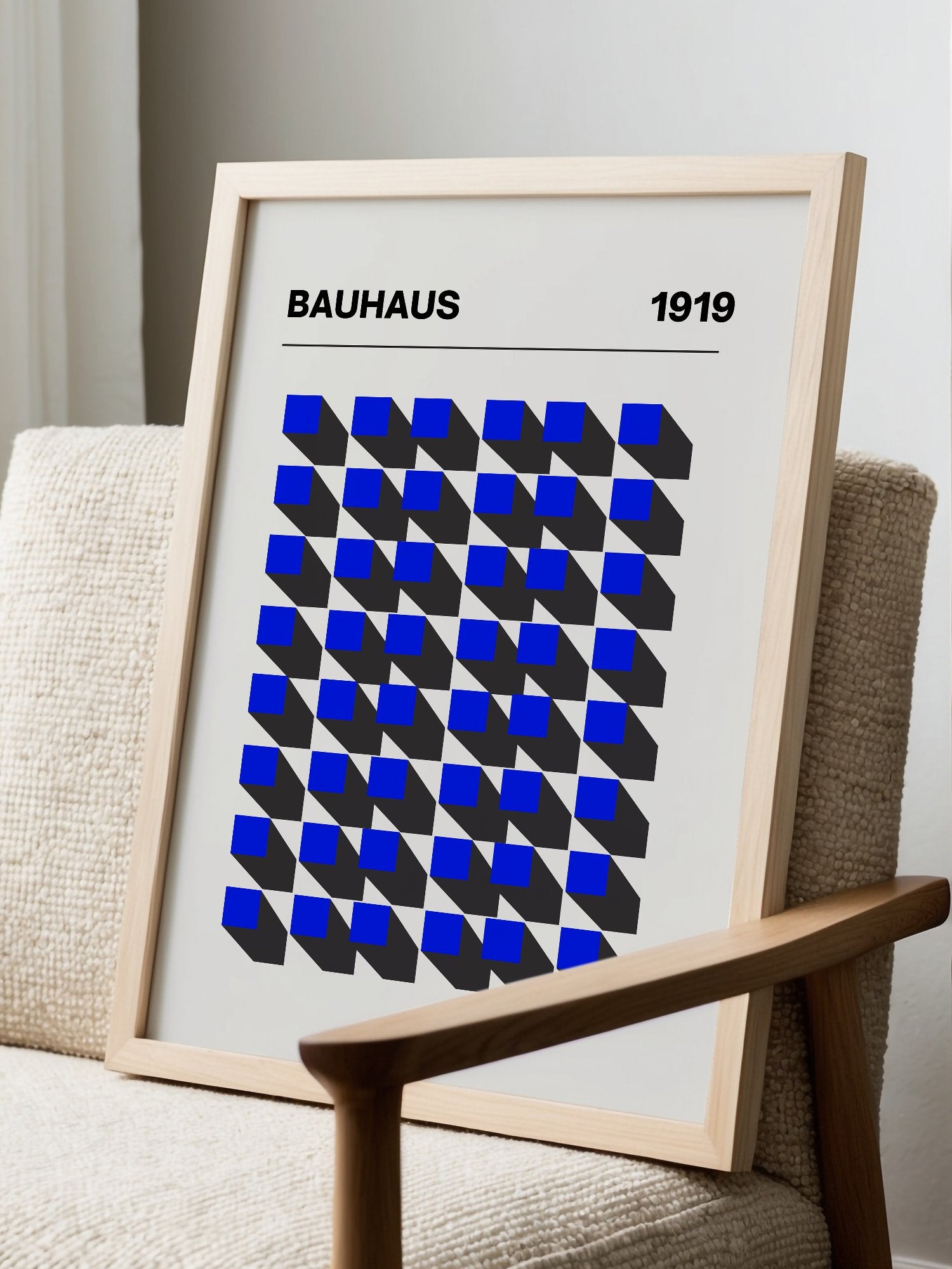 Bauhaus 1919 geometric poster featuring blue isometric cubes arranged in grid, displayed in modern living room setting