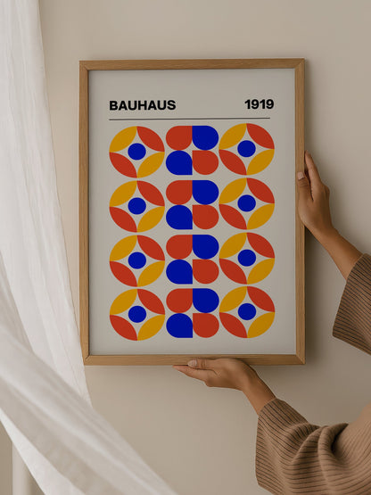 Bauhaus 1919 geometric poster featuring circular medallions in blue red yellow, hanging in contemporary bedroom interior