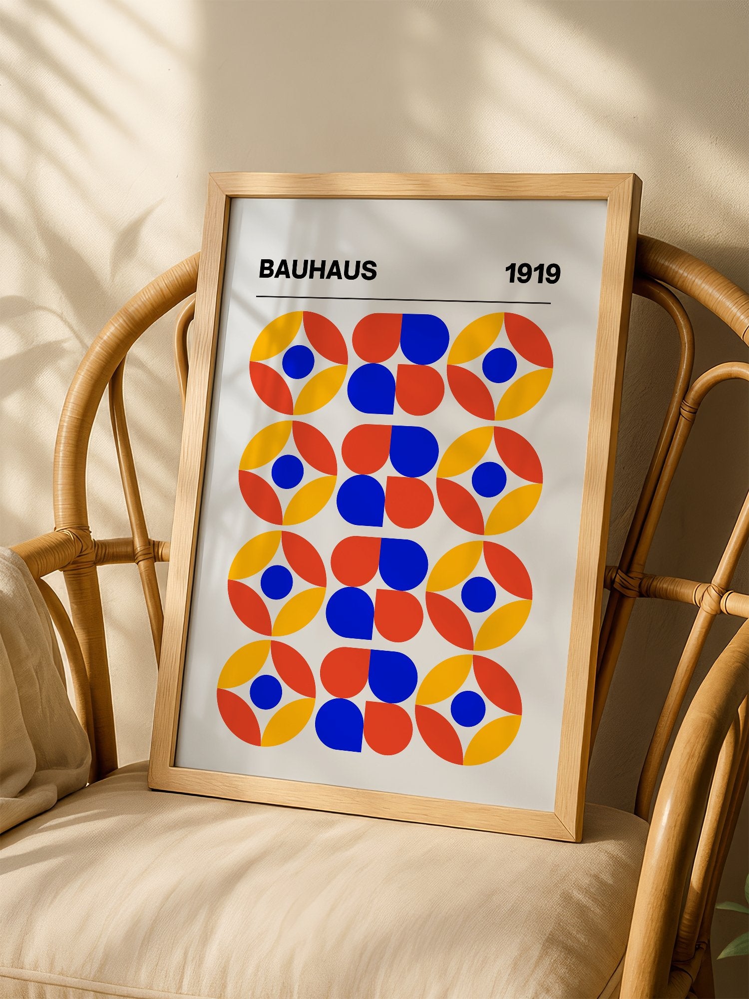Bauhaus 1919 geometric poster featuring circular medallions in blue red yellow, shown in minimalist home office space