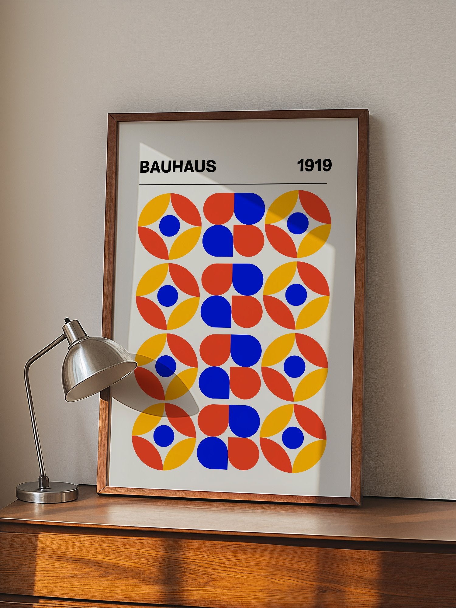 Bauhaus 1919 geometric poster featuring circular medallions in blue red yellow, displayed in modern living room setting