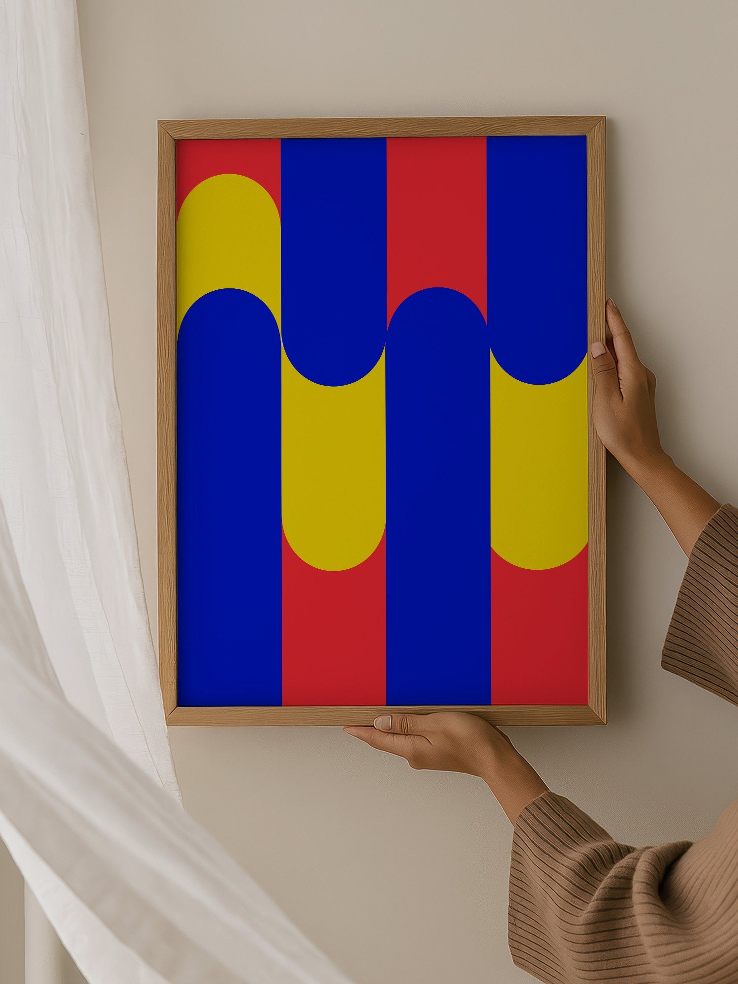 Geometric abstract art print with blue circles on yellow rounded rectangles, hanging in contemporary bedroom interior