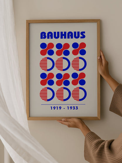 Bauhaus geometric poster featuring blue and red circles and semicircles in grid, hanging in contemporary bedroom interior