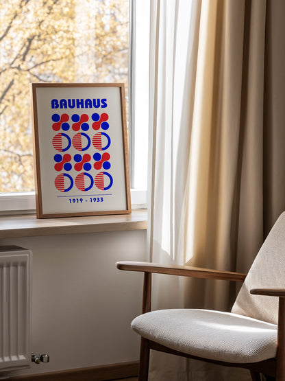 Bauhaus geometric poster featuring blue and red circles and semicircles in grid, mounted in bright gallery wall arrangement