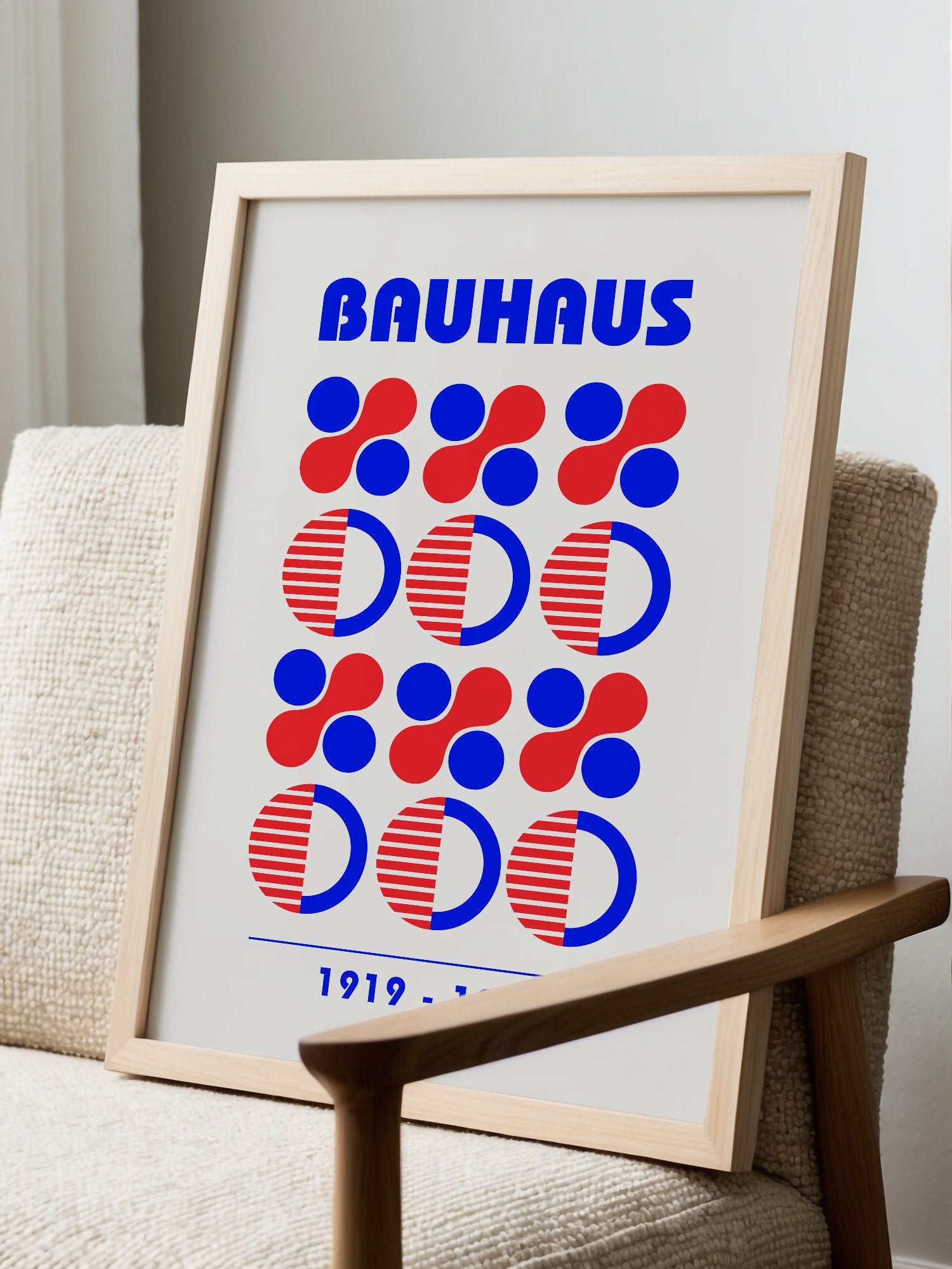 Bauhaus geometric poster featuring blue and red circles and semicircles in grid, displayed in modern living room setting