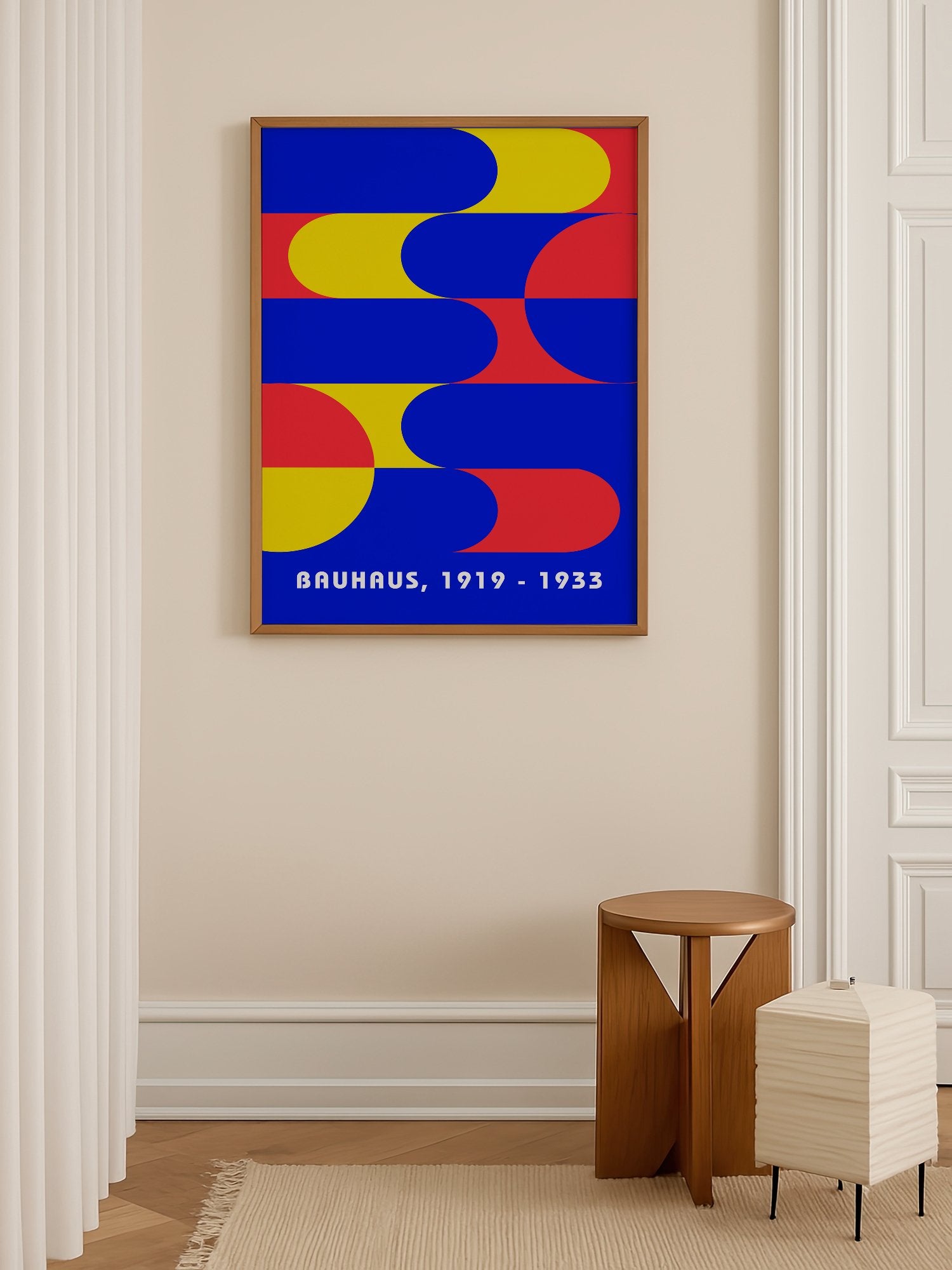 Bauhaus geometric abstract poster with interlocking blue yellow and red shapes, shown in minimalist home office space