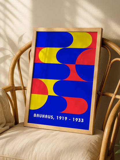 Bauhaus geometric abstract poster with interlocking blue yellow and red shapes, shown in minimalist home office space