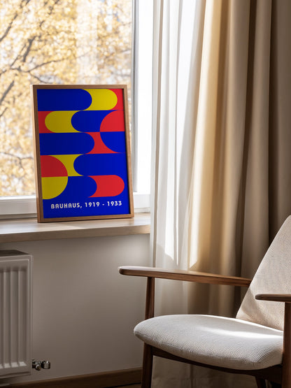Bauhaus geometric abstract poster with interlocking blue yellow and red shapes, mounted in bright gallery wall arrangement