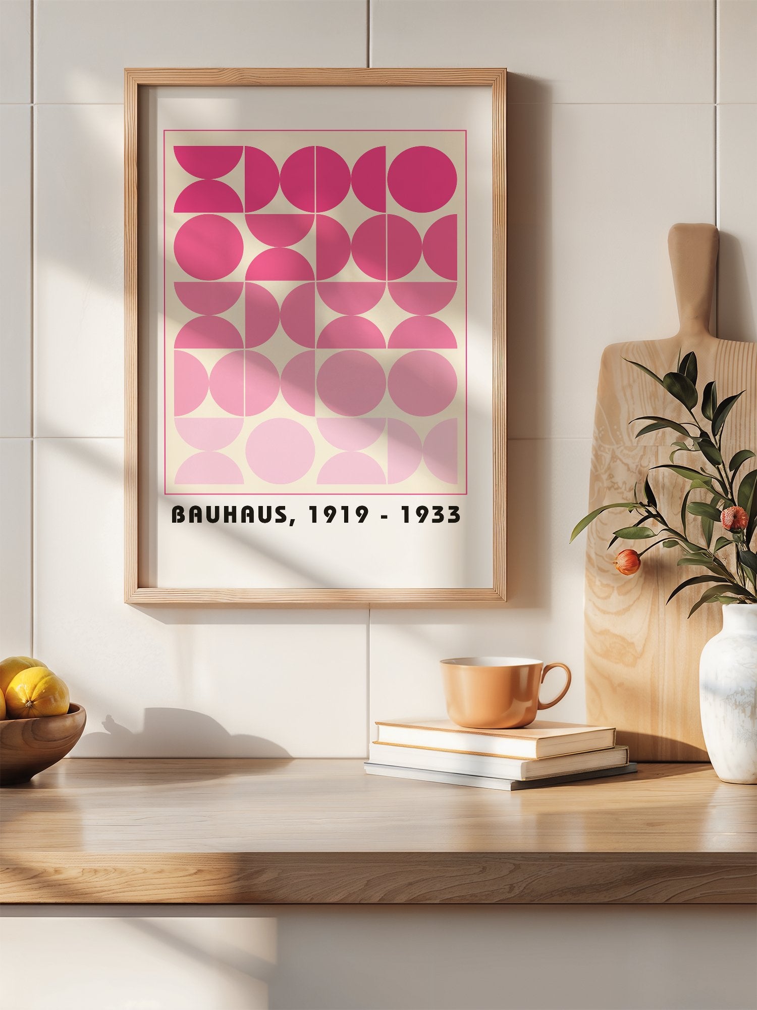 Bauhaus geometric poster featuring pink circles and semicircles in gradient, hanging in contemporary bedroom interior