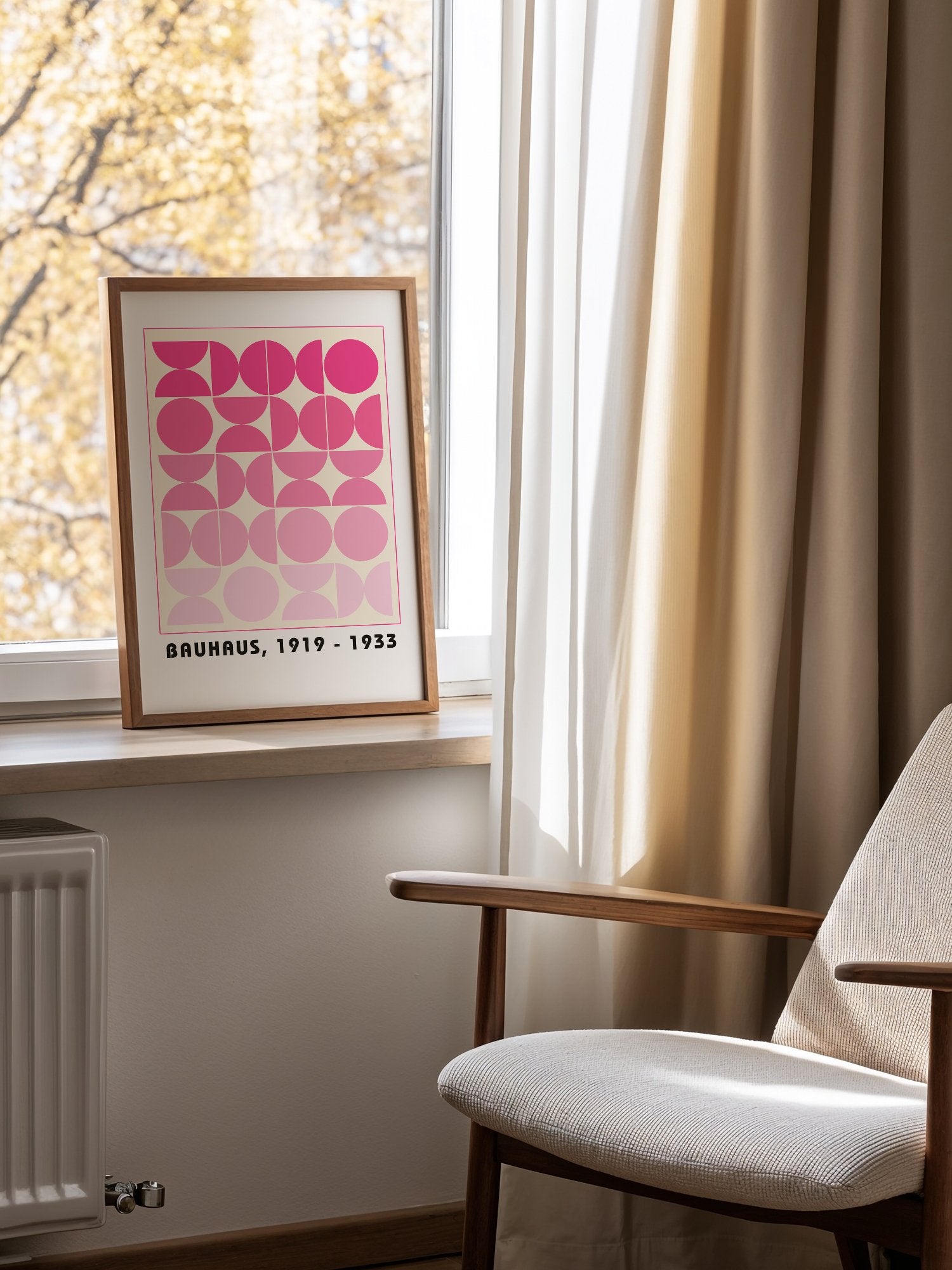 Bauhaus geometric poster featuring pink circles and semicircles in gradient, mounted in bright gallery wall arrangement
