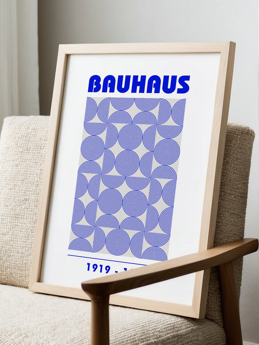 Bauhaus poster with bold blue typography and concentric circle grid pattern, displayed in modern living room setting