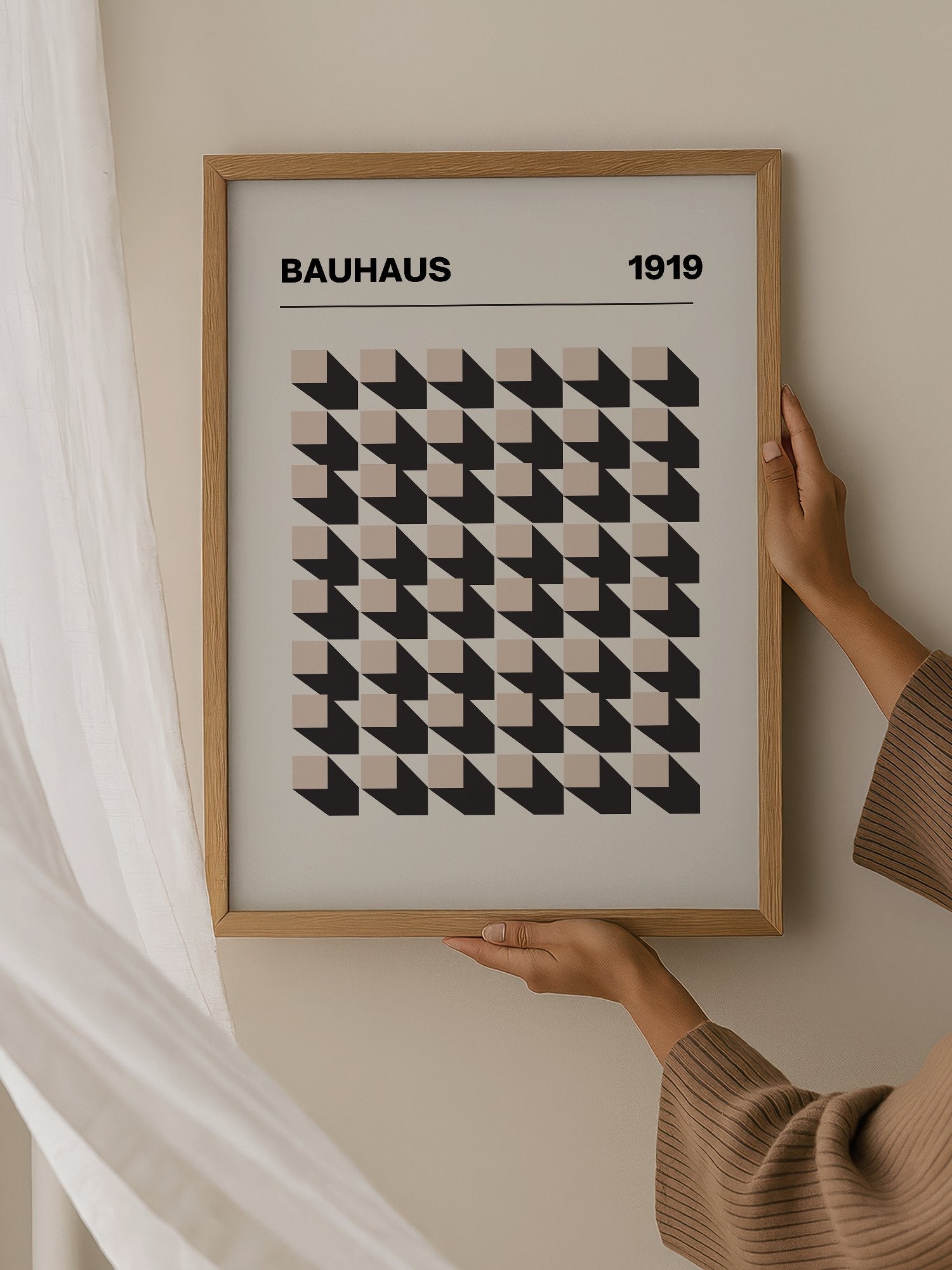 Bauhaus 1919 poster featuring grid of black and beige isometric cubes in, hanging in contemporary bedroom interior