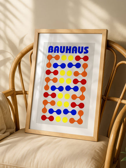 Bauhaus poster with bold blue typography and geometric grid pattern of circles, shown in minimalist home office space
