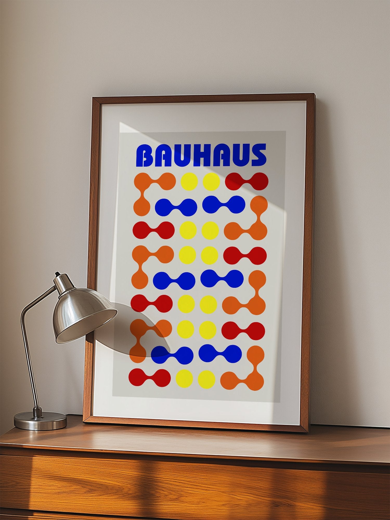 Bauhaus poster with bold blue typography and geometric grid pattern of circles, displayed in modern living room setting