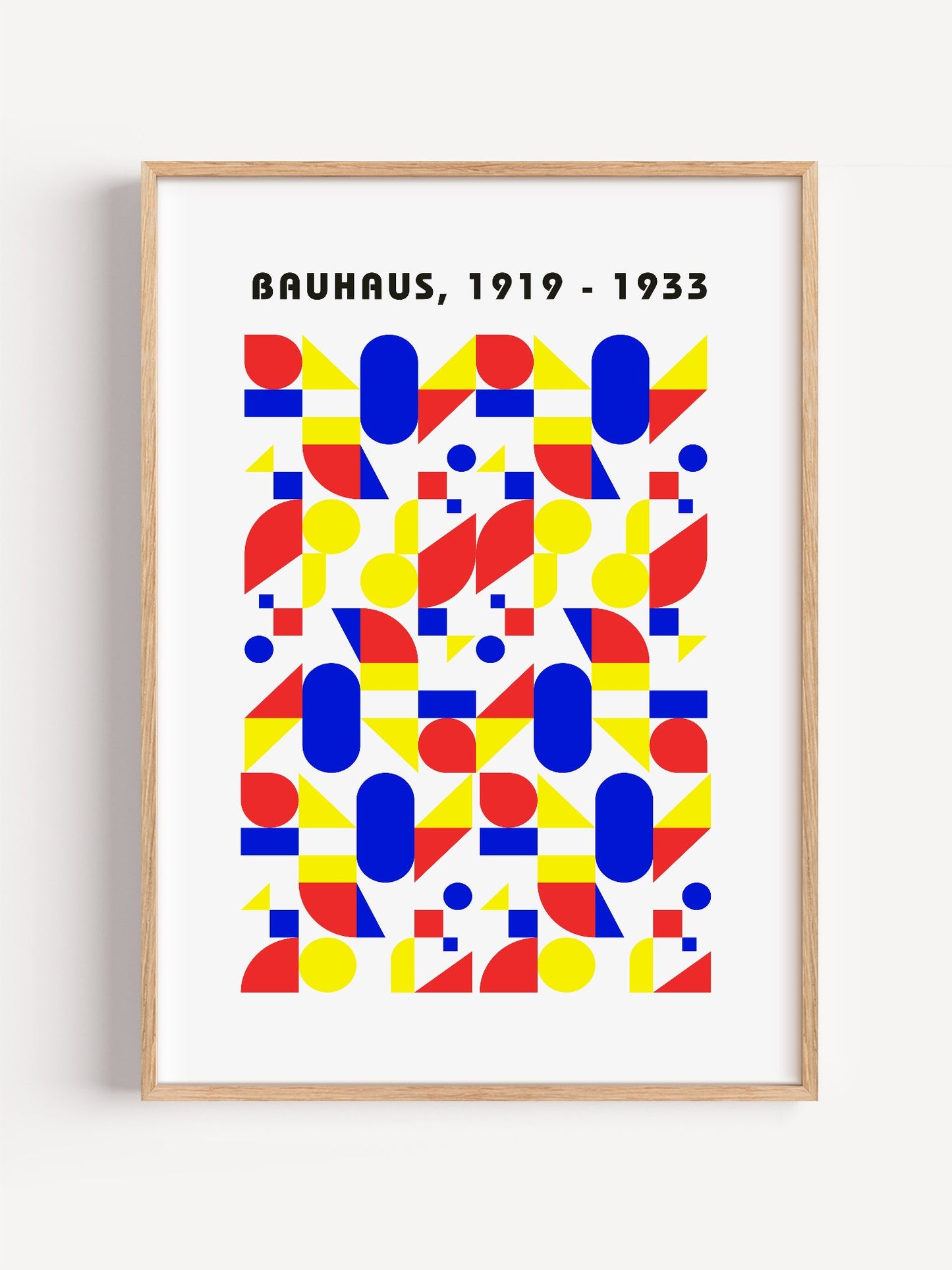 Bauhaus geometric poster with red circles, yellow triangles, and blue ovals in, close-up showing print texture and color d...