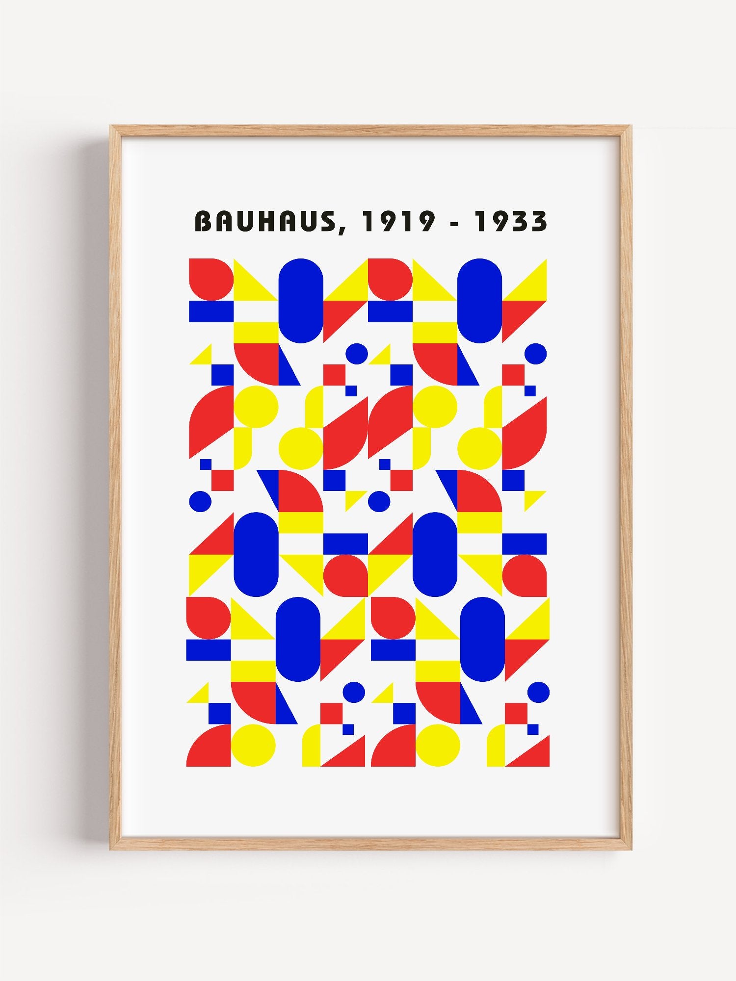 Bauhaus geometric poster with red circles, yellow triangles, and blue ovals in, close-up showing print texture and color d...