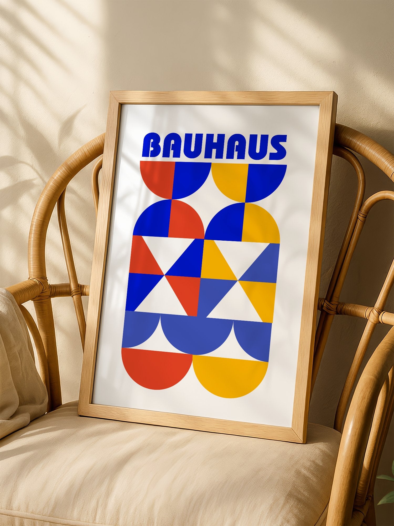 Bauhaus geometric poster featuring bold blue typography above symmetrical, shown in minimalist home office space