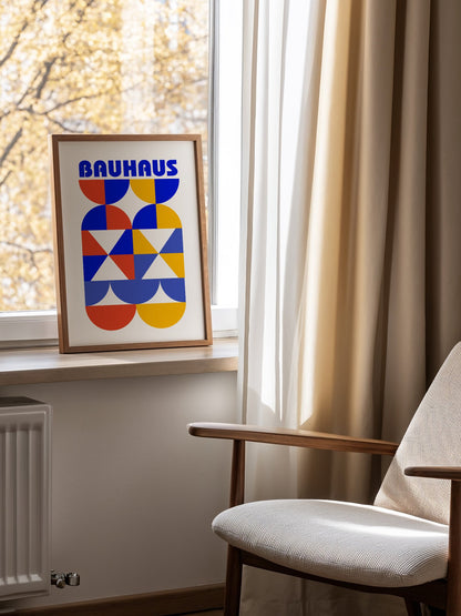 Bauhaus geometric poster featuring bold blue typography above symmetrical, mounted in bright gallery wall arrangement
