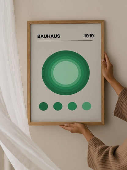 Bauhaus 1919 poster with concentric green circles in gradient shades on beige, hanging in contemporary bedroom interior