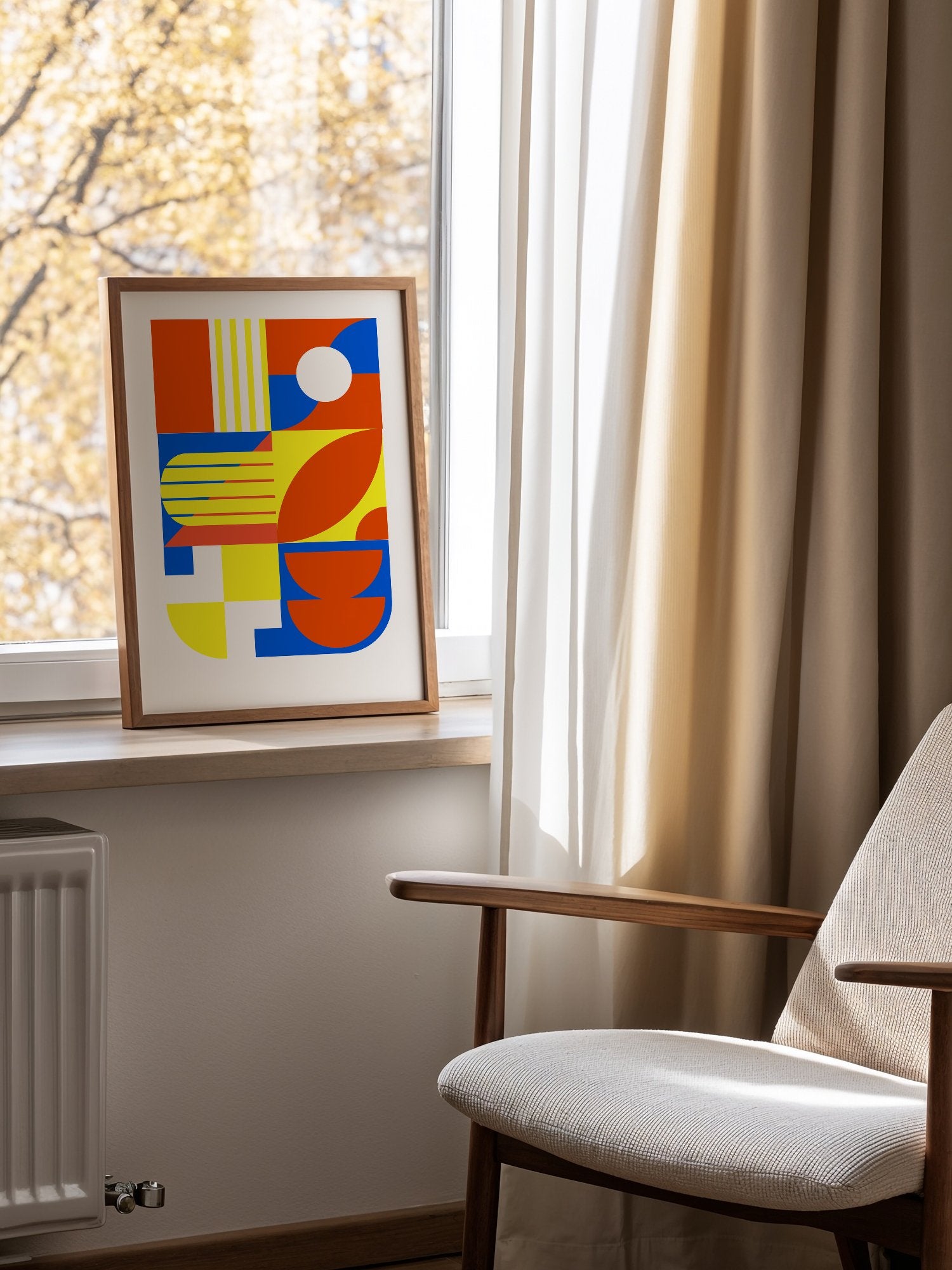Abstract geometric wall art with interlocking orange, blue and yellow shapes, mounted in bright gallery wall arrangement
