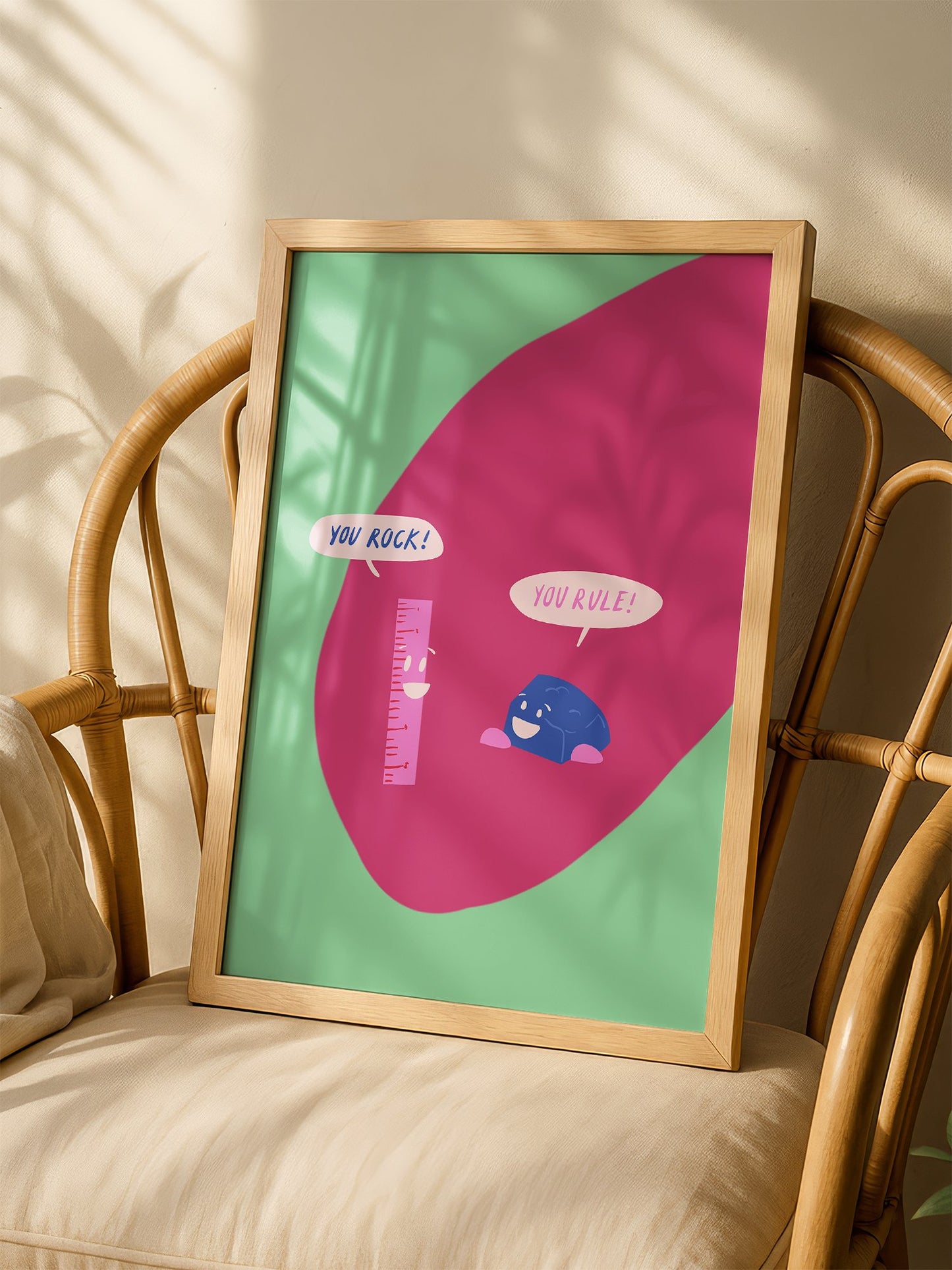 Cartoon ruler and rock character poster with 'You Rock!' and 'You Rule!' speech, shown in minimalist home office space