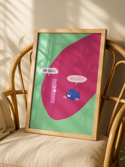 Cartoon ruler and rock character poster with 'You Rock!' and 'You Rule!' speech, shown in minimalist home office space
