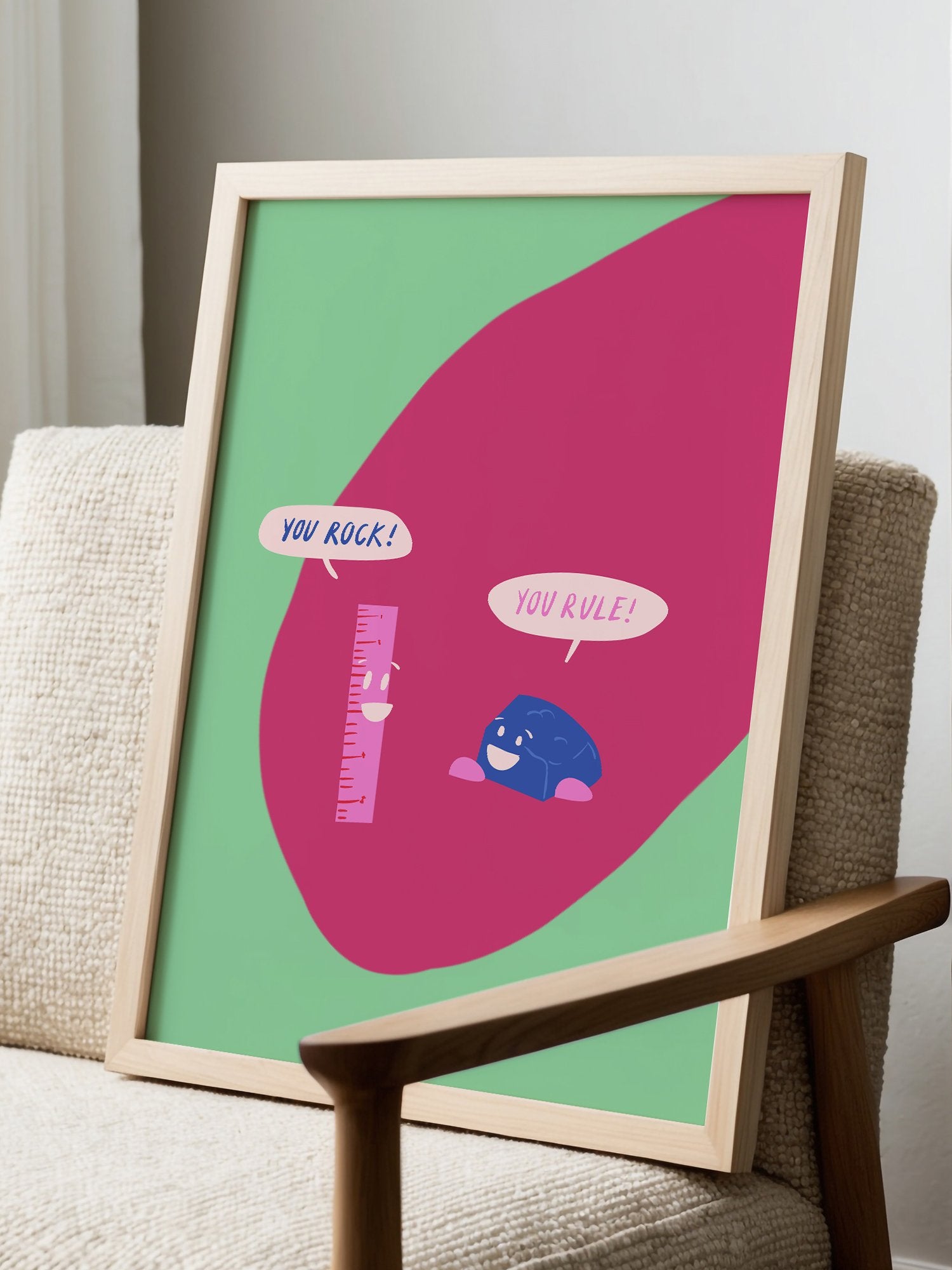 Cartoon ruler and rock character poster with 'You Rock!' and 'You Rule!' speech, displayed in modern living room setting