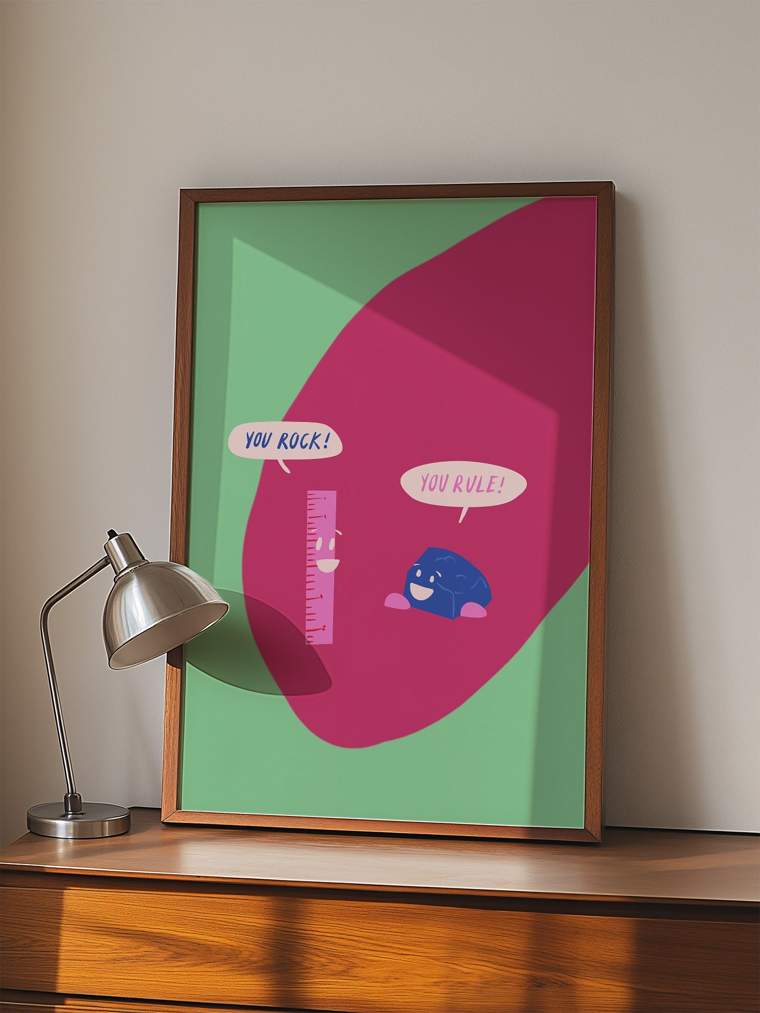 Cartoon ruler and rock character poster with 'You Rock!' and 'You Rule!' speech, displayed in modern living room setting