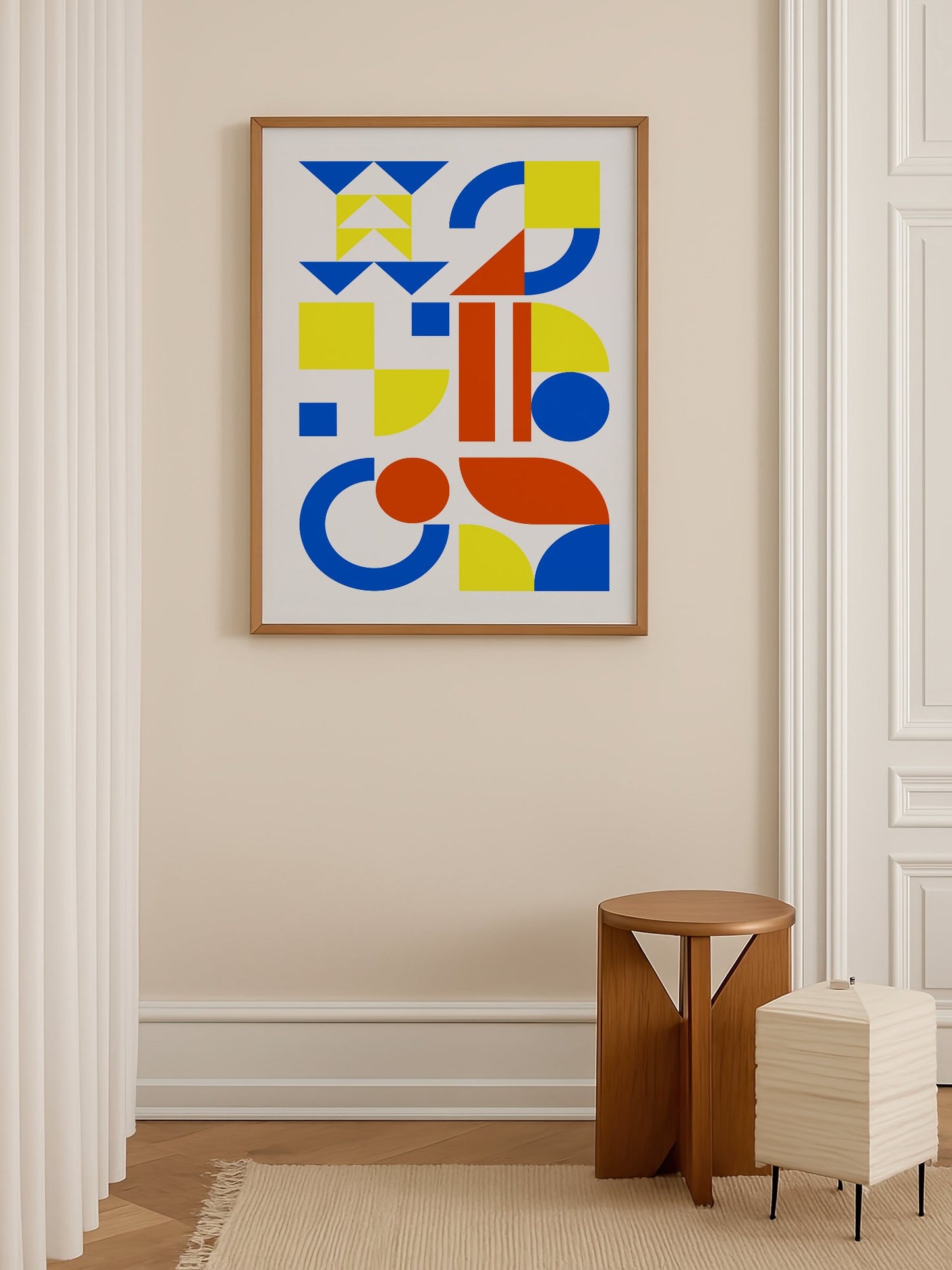Geometric abstract wall art with blue, yellow and red triangles, circles and, shown in minimalist home office space