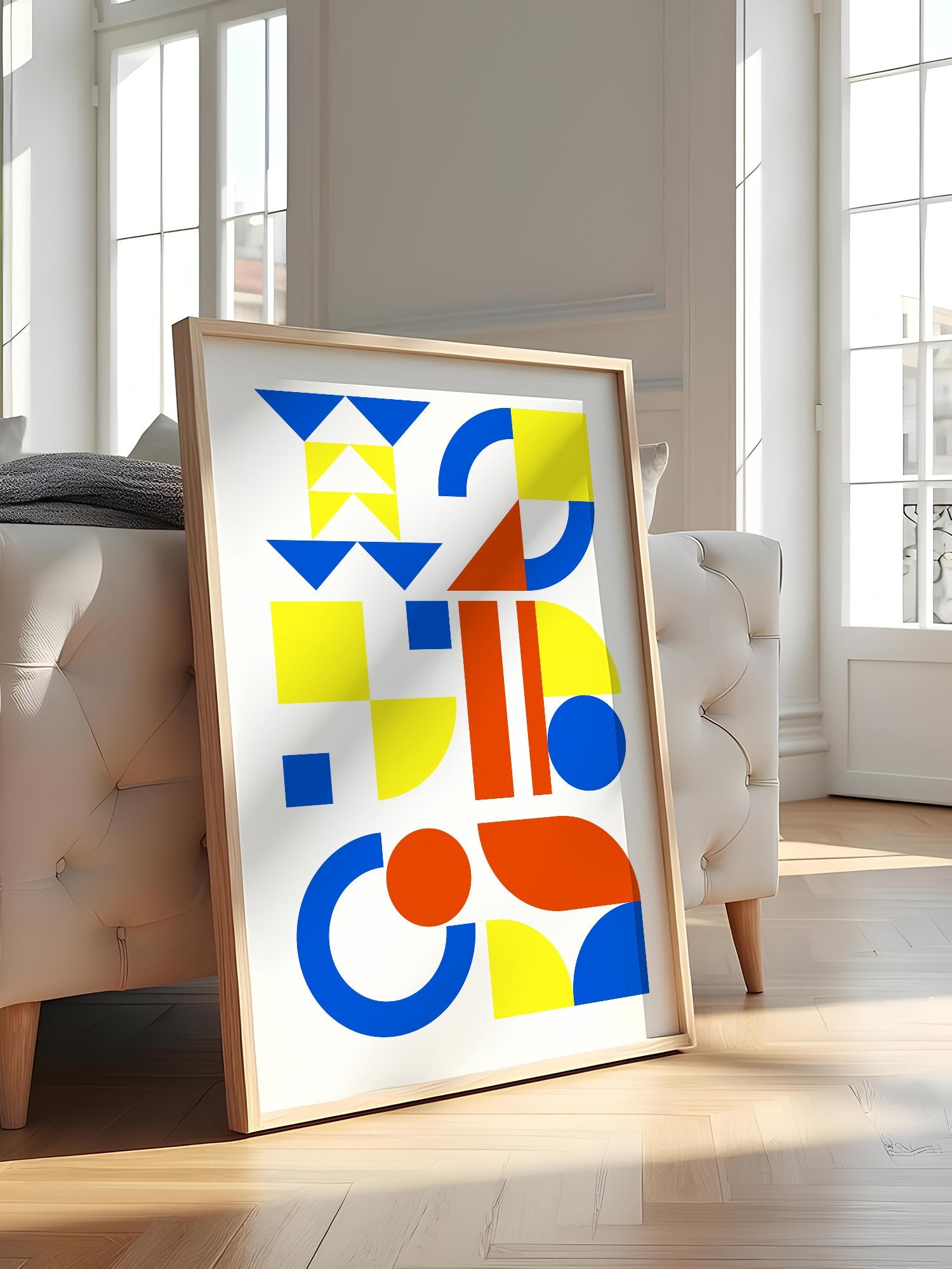 Geometric abstract wall art with blue, yellow and red triangles, circles and, featured in stylish apartment decor