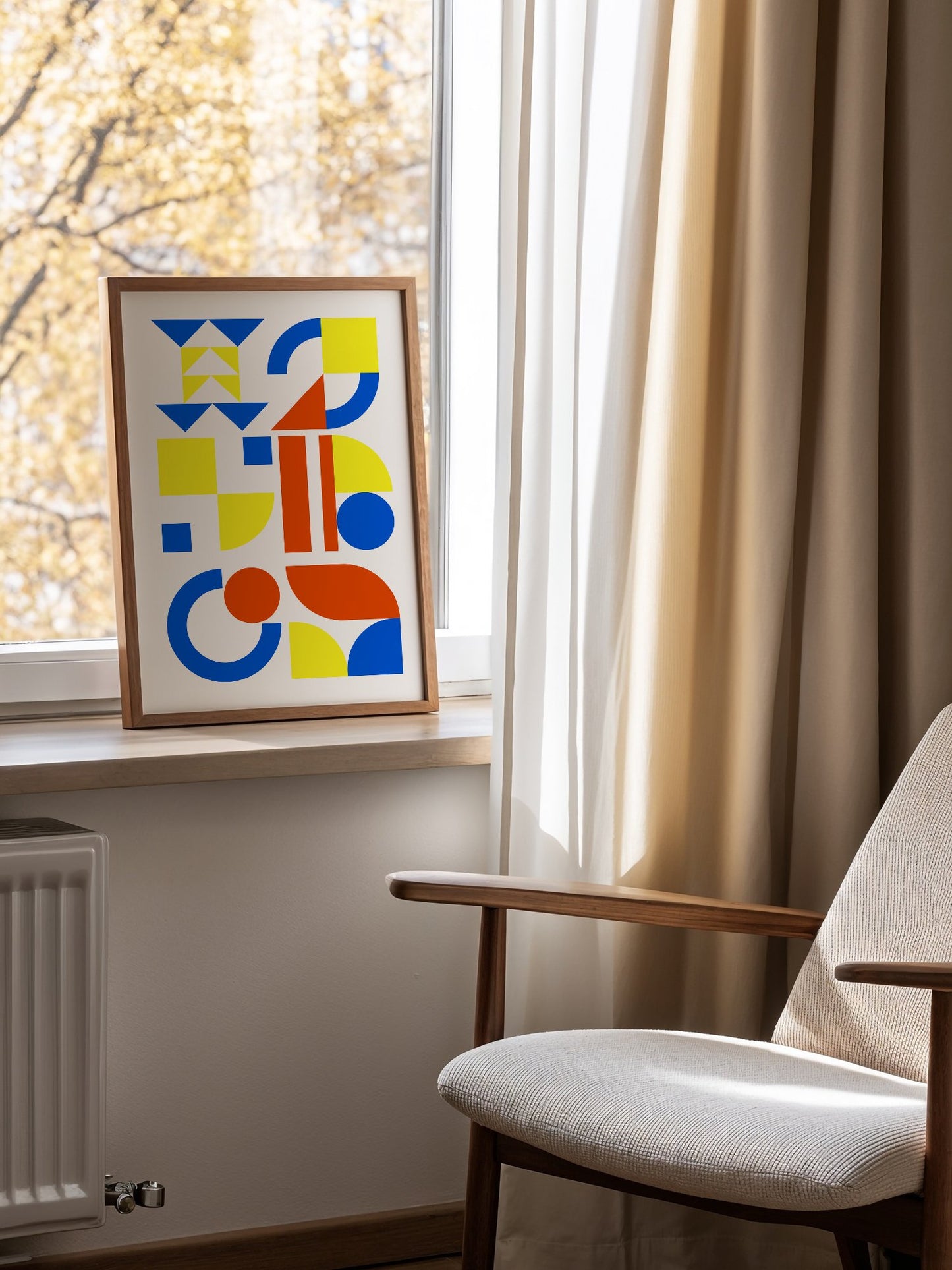 Geometric abstract wall art with blue, yellow and red triangles, circles and, mounted in bright gallery wall arrangement