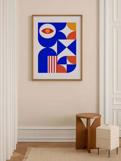 Geometric abstract art print with red eye motif, blue background, coral and, shown in minimalist home office space