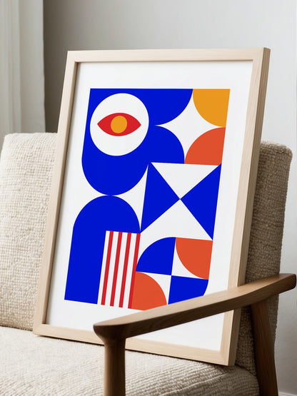 Geometric abstract art print with red eye motif, blue background, coral and, displayed in modern living room setting